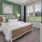 a bedroom with a bed large window and a table